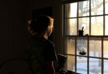 lonely woman standing by window