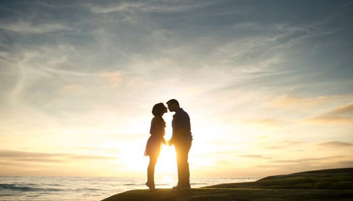 Couple kissing at sunset near water