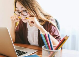 6 Stress Management Exercises That Really Work woman biting pencil while sitting on chair in front of computer during daytime