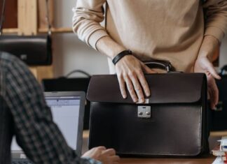 Employee Packing Items in Leather Laptop Briefcase