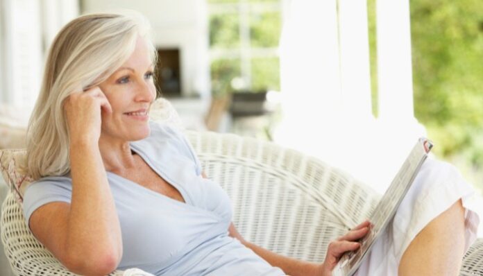 Woman With Hormonal Imbalance Woman Sitting in the Sun Reading About Hormonal Imbalance