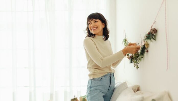 Making House Feel Like Home Woman Hanging Decor in New Home