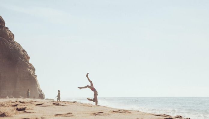 Beach Days Woman Doing Cartwheels on Beach