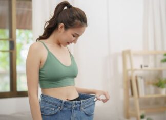 Woman Looking at Weight Loss Progress She has Made