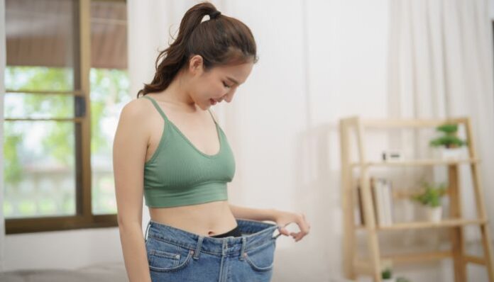Belly Fat Gone Woman Looking at Weight Loss Progress She has Made