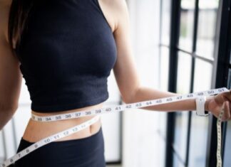 Woman With An Eating Disorder Measuring Weight Loss