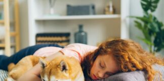 How To Recognize Sleep Disruption Before It Becomes Chronic Woman Sleeping With Dog and Having Sleep Disruption