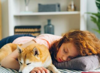 How To Recognize Sleep Disruption Before It Becomes Chronic Woman Sleeping With Dog and Having Sleep Disruption