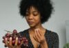 curly haired woman eating 12 grapes