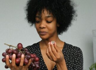 12 New Year’s Eve Traditions You Might Want To Try This Year curly haired woman eating 12 grapes
