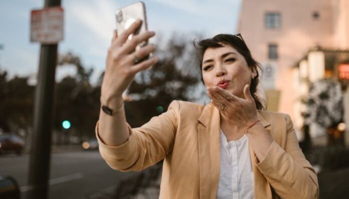 Woman Blowing Kiss on Video Call With Friend to Celebrate Special Day Long Distance