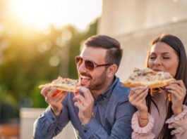 Couple eating Pizza While Traveling