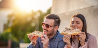 Couple eating Pizza While Traveling