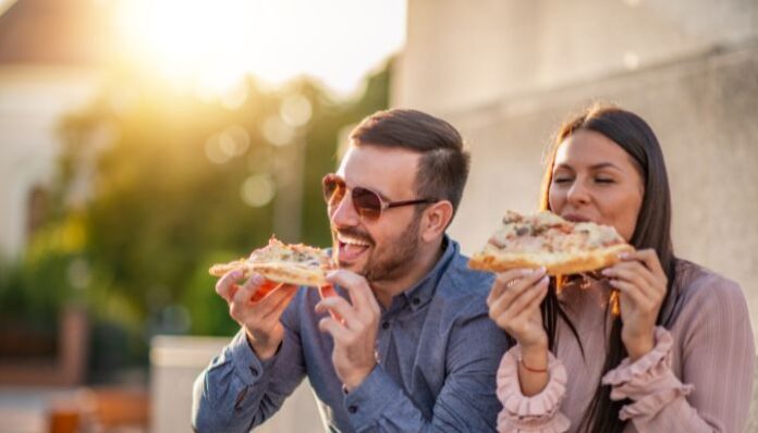 Couple eating Pizza While Traveling
