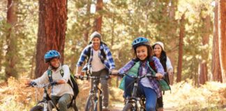 Mixed Race Family Riding Bikes in California Forest