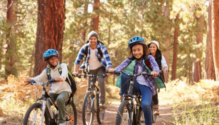 Mixed Race Family Riding Bikes in California Forest