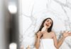 Woman Singing in Bathroom With White Tile Wall
