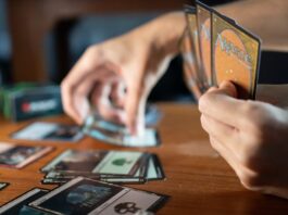 Person Playing Magic The Gathering at a Wooden Table