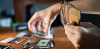 Person Playing Magic The Gathering at a Wooden Table