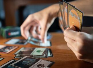 Person Playing Magic The Gathering at a Wooden Table