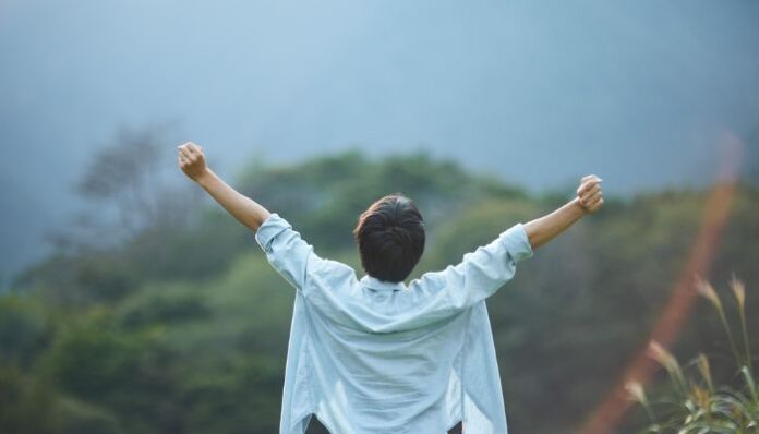 Person Celebrating Growth and Accomplishment Outdoors