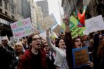 Demonstrators react as they march past Trump Tower as they protest through Manhattan demanding U.S. President Donald Trump release his tax returns